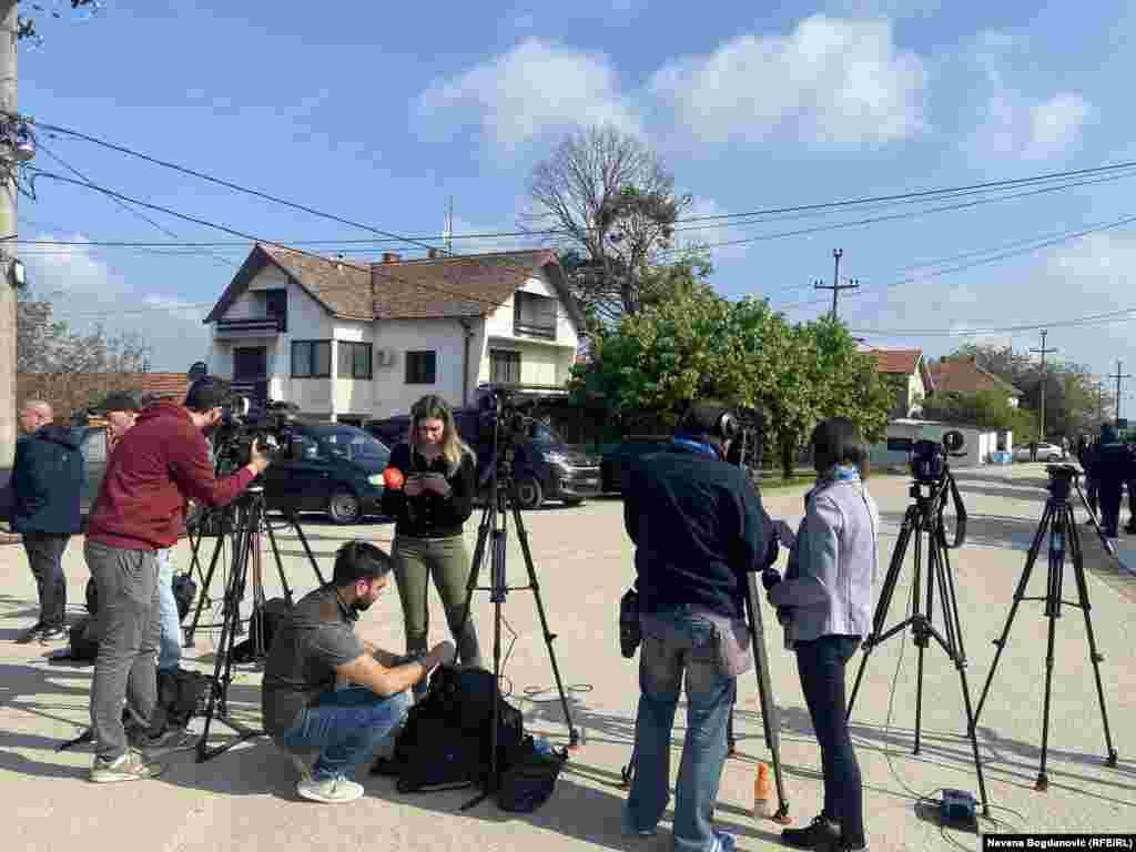 Medijske ekipe su u centru sela, udaljene nekoliko desetina metara od mesta gde se zločin dogodio. Prisutna je i vojna policija i vojna vozila.