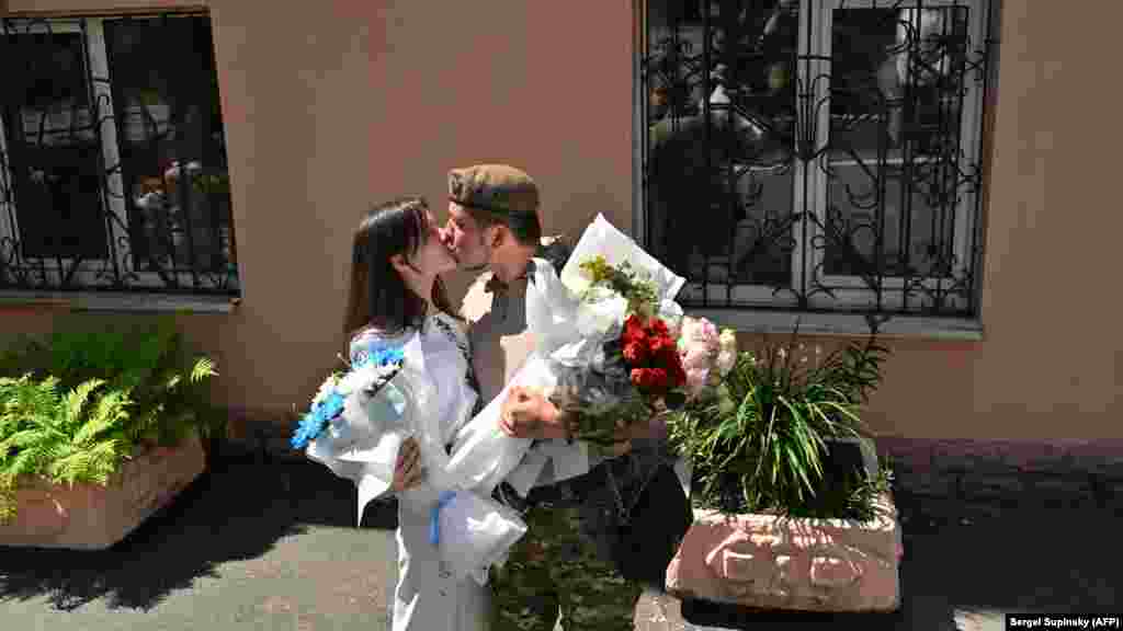 25-летний украинский военнослужащий Виталий целует свою жену сразу после обмена брачными обетами в Киеве 23 июля. Вот как выглядит украинский "свадебный бум" в цифрах: за последние пять месяцев в Киеве зарегистрировали 9120 браков, притом что за аналогичный период в 2021 году поженились только 1110 пар.