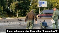 Ova slika koju je Ruski istražni komitet objavio 21. avgusta 2022. pokazuje kako istražitelji rade na mjestu eksplozije automobila kojim je upravljala Darja Dugina