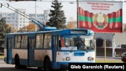Stari trolejbus u gradu Tiraspolu prolazi pored banera sa grbom samoproglašene separatističke regije Pridnjestrovlje u Moldaviji, 3. novembar 2021.
