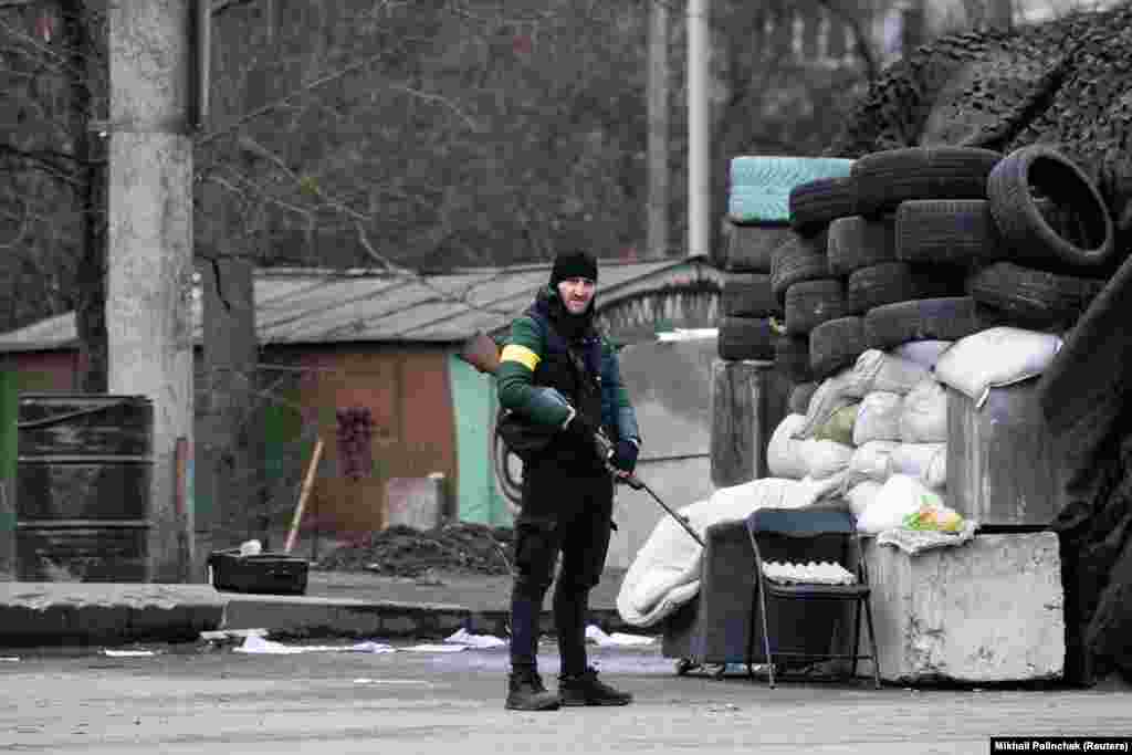 Pripadnik ukrajinske Teritorijalne odbrane stražari s lovačkom puškom u predgrađu Kijeva 4. marta. Dobrovoljci Teritorijalne odbrane su grupa obučenih civila pod komandom ukrajinske vojske čiji zadaci uključuju oružani otpor invaziji i "zaštitu javne vlasti, lokalne samouprave, kritičnih i objekata komunikacije".
