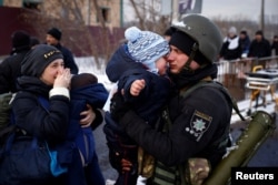 Un polițist ucrainean se desparte de fiul său, în Irpin. Evacuarea populației continuă și marți, 8 martie 2022, în timp ce forțele Rusiei continuă să atace și să avanseze spre acest oraș.