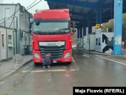 Vozač kamiona iz Srbije lepi nalepnice na državne simbole na registarskim tablicama. Jarinje, 22. april 2022.