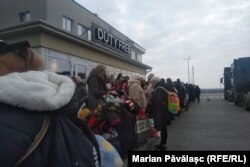 Coada de la frontiera ucraineană din Orlivka, oamenii așteaptă să ofere bonul cu ștampile care le permite ieșirea din Ucraina