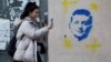 Podgorica: Djevojka prolazi pored grafita sa likom ukrajinskog predsjednika Volodimira Zelenskog, mart 2022.