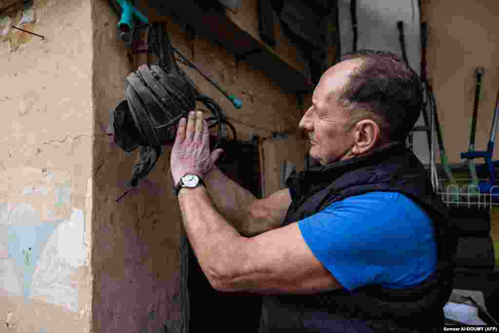 Андрій Плешан показує шлем російського танкіста. Подібних «подарунків» залишених російськими військовими у місті чимало. Люди жили в страху перед російськими військовими, які регулярно приходили обшукувати тих, хто ховався в підвалах. «Нас могли вбити будь-коли», – згадує Андрій Плешан, – «Це страждання об’єднало нас»