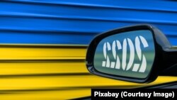 Godina 2022. u retrovizoru, zastava Ukrajine u pozadini.