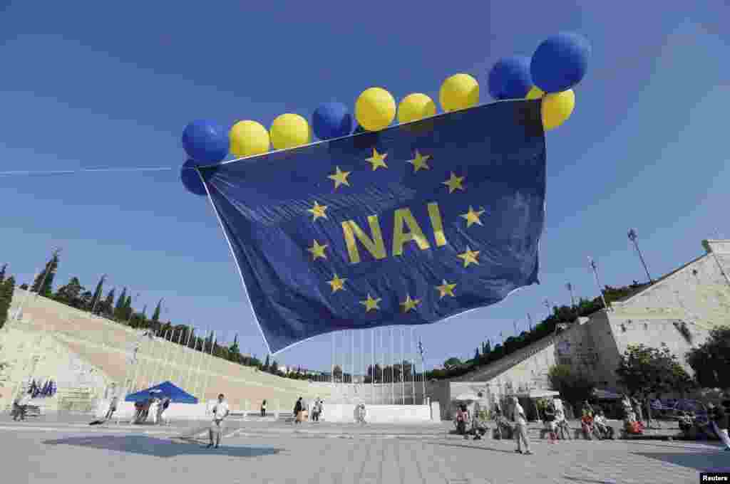 Флаг ЕС с надписью "ДА" запустили в воздух участники митинга сторонников сотрудничества с кредиторами на митинге в Афинах 3 июля.  