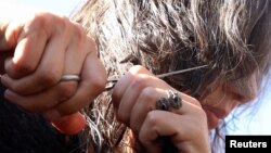 Žena odsijeca kosu tokom protesta zbog smrti 22-godišnje Mahse Amini u Iranu, grad Kamišli pod kontrolom Kurda na sjeveroistoku Sirije, 26. septembar 2022. 