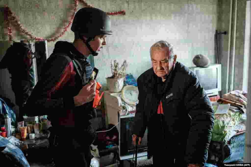 Član nevladine organizacije pomaže Solovjankovu (desno) u evakuciji iz Bahmuta.