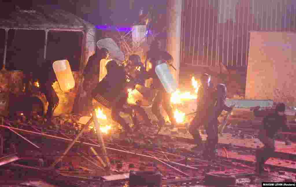 Украинский спецназ прячется от зажигательных устройств, брошенных проевропейскими протестующими во время митинга в Киеве 19 января 2014 года. Около 100 тысяч человек вышли на демонстрацию в столице, несмотря на законы, запрещающие стихийные акции. Протесты в Украине вспыхнули после того, как в ноябре 2013-го правительство приостановило подготовку к подписанию Соглашения об ассоциации с Европейским союзом и вместо этого решило выстраивать более тесные экономические отношения с Россией 