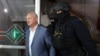 Bivši predsjednik Igor Dodon u pratnji policijskih službenika pred sudsko saslušanje u Kišinjevu u maju 2022.