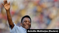 Bivši brazilski fudbaler Pele maše gledaocima pred početak finalne fudbalske utakmice za dečake do 17 godina na turniru u Nju Delhiju, 16. oktobar 2015. 