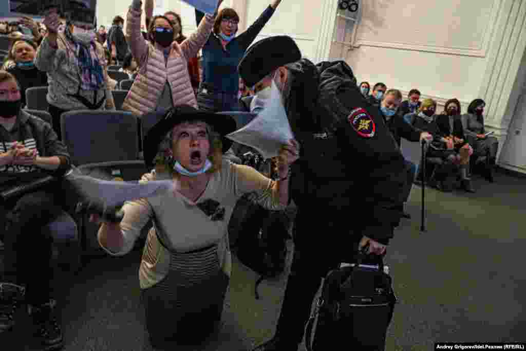 Активистка Гульнара Гилязова встаёт на колени перед перед президиумом, в котором сидит депутат Казгордумы Людмила Андреева, чтобы привлечь внимание парламентария к очередной незаконной засыпке Волги. Андреева попросила полицию вывести активистку из зала, Казгордума засыпку проигнорировала.