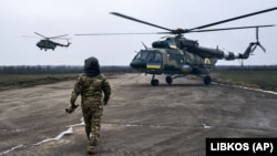Pilot se približava svom helikopteru u ukrajinskoj vojnoj zračnoj bazi blizu linije fronta u regiji Herson.