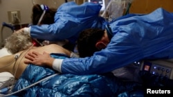 Sin i kćerka grle svog oca, oboljenog od COVID-a 19, na odjelu intenzivne njege u bolnici, Kalifornija, SAD, 25. siječnja 2022.