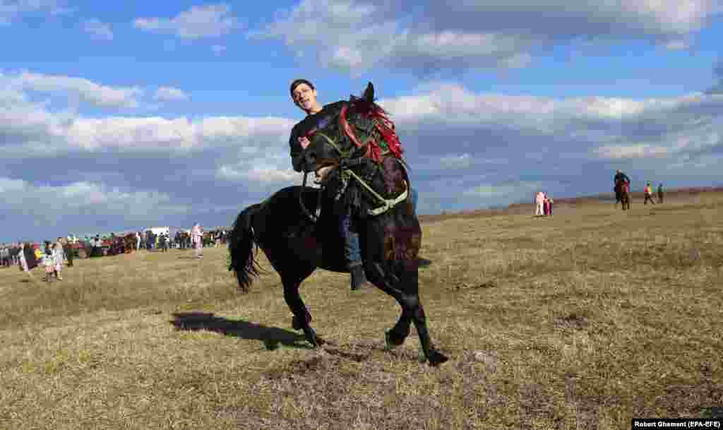 Вершник розігріває свого коня перед Хрещенськими перегонами, які проводяться в селі П’єтрошань, за 50 км на північ від Бухареста, Румунія, 6 січня 2023 року. Селяни з П’єтрошань та навколишніх сіл благословляють своїх коней на свято Хрещення Господнього, яке в Румунії вважається святом, що закінчує цикл Різдвяних свят. Після освячення коні та вершники у супроводі громади беруть участь у вільних кінних перегонах на околиці села