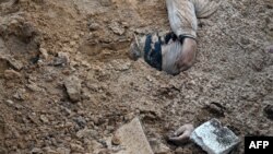 Tijelo delimično prekriveno u masovnoj grobnici u Buči, blizu Kijeva. Ukrajinski zvaničnik je rekao 10. aprila da je još jedna masovna grobnica pronađena u selu Buzova, kod ukrajinske prijestolnice.