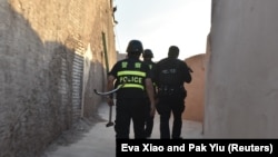 Kineski policajaci patroliraju ulicama grada Kašgara, u provinciji Ksininjajng na zapadu Kine, u vreme praznika Ramazana. U ovoj oblasti uništen je veliki broj svetilišta za muslimansku zajednicu Ujgura. Zabeleženo 3. juna 2019.