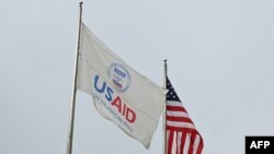 USAID-ისა და აშშ-ის დროშები შეერთებული შტატების საერთაშორისო განვითარების სააგენტოს შტაბ-ბინის წინ. ვაშინგტონი, 3 თებერვალი, 2025.