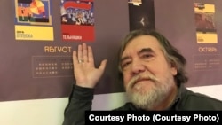 Дмитрий Шагин с постером своей картины. Баннер "Митьки никого не хотят победить" сотрудники музея уже закрасили