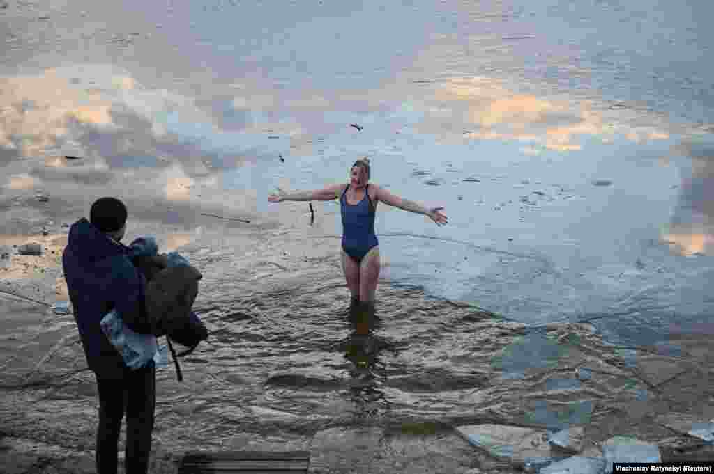 Жінка стоїть у крижаній воді, яка, як вважається, має чудодійну силу на Водохреще  (християнське свята Хрещення Господнього за юліанським календарем). Буча, Київська область, Україна. 19 січня 2023 року