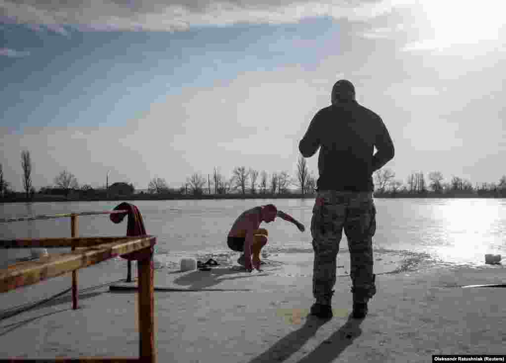 Українські військовослужбовці готуються пірнути в крижану воду на Водохреще (свято Хрещення Господнього) за юліанським календарем у час війни Росії проти України.  Слов'янськ, Донецька область, Україна. 19 січня 2023 року