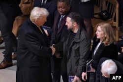 Обраний президент США Дональд Трамп тисне руку президенту України Володимиру Зеленському у соборі Паризької Богоматері на церемонії з нагоди його повторного відкриття. Париж, Франція, 7 грудня 2024 року