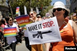 Žena koja maršira sa aktivističkom grupom 'Moms Demand Action' sa transparentom na kojem piše "Učinite da prestane", tokom Parade ponosa u San Franciscu, 26. juni 2016.