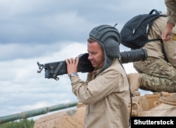 A Russian soldier carries a grenade launcher out of a BMPT Terminator near Moscow in 2017.