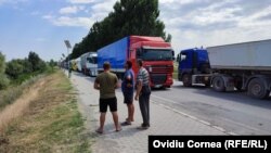 Șoferii parcați pe drumul portului schimbă impresii legate de momentul când vor putea intra în vamă.