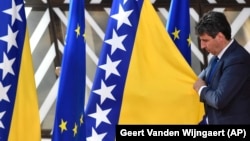 Član protokola namješta zastavu Bosne i Hercegovine pored zastave EU u Briselu, juni 2022.