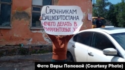 Vera Popova iz Ufe, koja je daleka rođaka regruta, drži plakat na kojem regrutima poručuje da ne idu u područja blizu linija fronta s Ukrajinom.