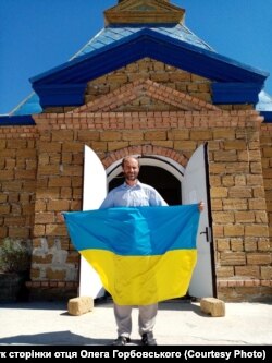 Отець Олег біля церкви на Арабатській стрілці