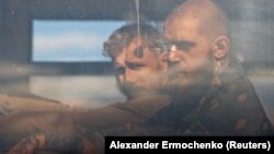 Pripadnici ukrajinskih snaga iz Azovstala u autobusu pod pratnjom proruske vojske u Mariupolju, 17. maj 2022. 