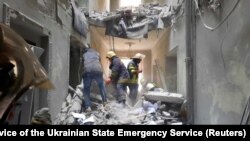 Spasioci u zgradi za koju zvaničnici kažu da je uništena u centru Harkova, 1. mart 2022. 