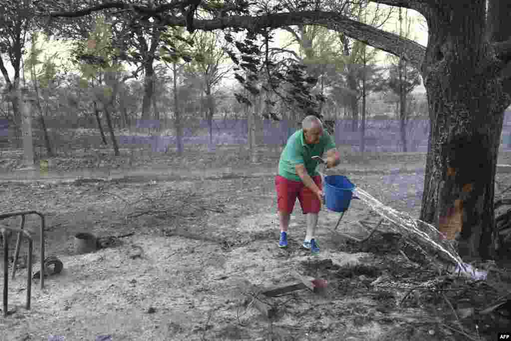 Čovjek na spaljenom imanju u selu Pumarejo, sjeverna Španija, 18. juli 2022.