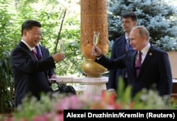 Russian President Vladimir Putin (right) toasts Chinese President Xi Jinping on his birthday in Dushanbe in 2019. The deepening relationship is now being tested as the Kremlin threatens a full-scale attack on Ukraine.