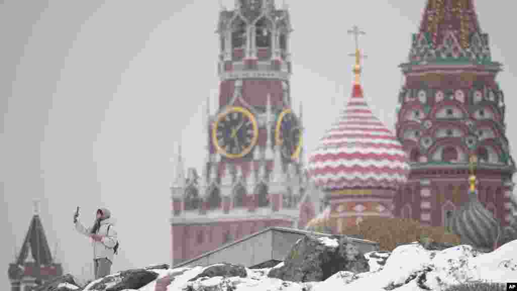 Žena pravi selfije u centru Moskve s Kremljom i katedralom Svetog Vasilija u pozadini nakon snježnih padavina u ruskoj prijestolnici.