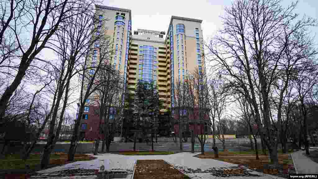 Эта 18-этажка «Триумф» находится в центре парка на месте кинотеатра «Мир». В экcплуатацию ее еще не сдали