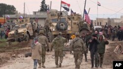 Російський, сирійський та американський прапори на військовій техніці під час протистояння в районі села