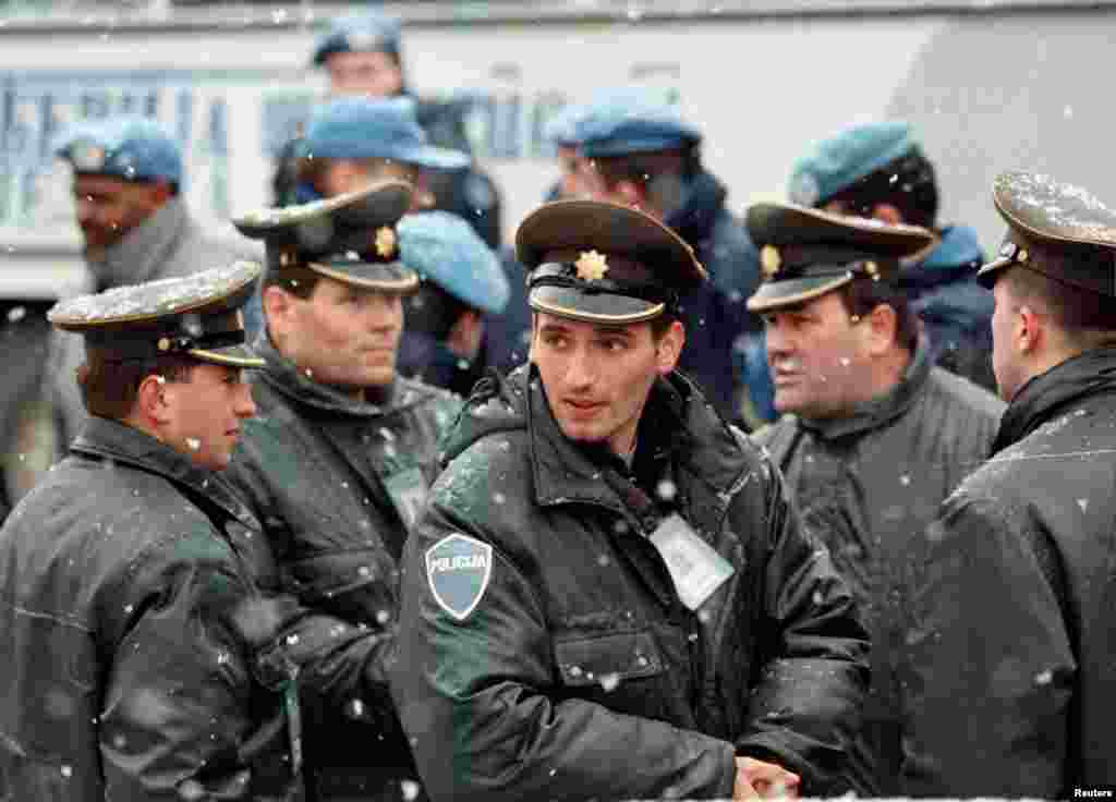 Policija bosanske vlade i posmatrači Ujedinjenih Nacija čekaju daljnjaa naređenja u centru Vogošće, naselja koje su tokom opsade grada pod kontrolom držale snage bosanskih Srba i koje je Dejtonskim sporazumom pripalo Federaciji BiH. 23. februar. 1996.