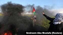 Žena drži palestinsku zastavu tokom protesta na granici između Izraela i Gaze, u južnom pojasu Gaze 22. februara 2019. godine.