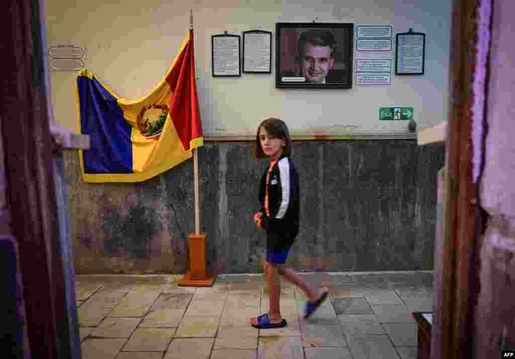 Dijete prolazi pored portreta pokojnog komunističkog diktatora Nicolaea Ceausescua i zastave socijalističke Rumunije izložene za posjetioce u privatnom muzeju u gradu Baile Herculane u Rumuniji.