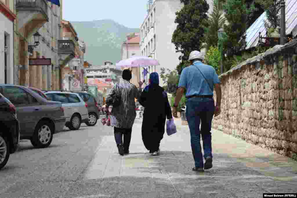 Dvije gošće, snimljene u pješačkoj zoni u Fejićevoj ulici u Mostaru, od sunca su se zaštitile – kišobranom.