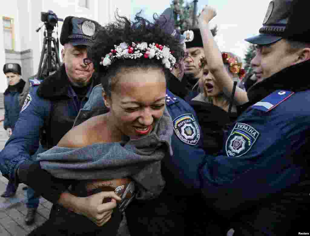 Киевалда полициялъ ккурай  Femen къукъаялъул гIахьалчIужу. Гьаб нухалда гьел рахъун рукIана гьомофобиялде данде протест лъазабизе. 12Ноя2015  (Reuters/Gleb Garanich)