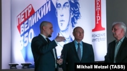 Россия. Москва. Президент РФ Владимир Путин (в центре) и управляющий директор Фонда гуманитарных проектов, директор исторического парка "Россия – моя история" Иван Есин (слева) во время посещения мультимедийной выставки "Петр I. Рождение Империи" на ВДНХ.