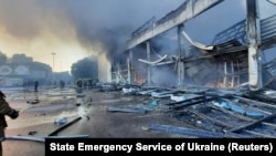 Spasioci rade na mjestu tržnog centra pogođenog ruskim raketnim udarom u Kremenčuku 27. juna 2022.