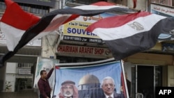 Prodavac prikazuje poster vođa Hamasa u pojasu Gaze Ismail Hanija (levo) i predsednik Fataha Mahmud Abas ispred svoje prodavnice u Gaza City 28. april 2011.