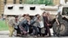 Građani i građanke Sarajeva u zaklonu od snajpera iza vojnog vozila francuskih mirovnih jedinica u centru grada, 6. jun 1995. godine